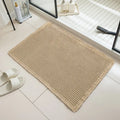 Square checkered polyester bathroom carpet on a tiled floor in a light grey colour.