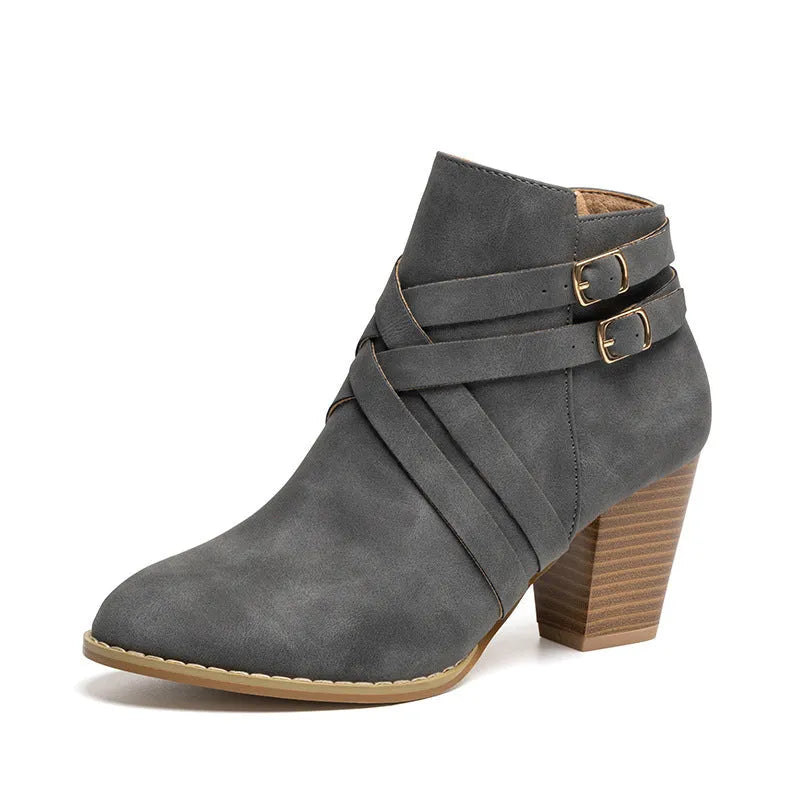 Grey plus-size short boot with 7cm heel, side zip, and buckle detail on a wooden floor