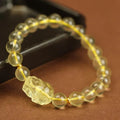 Yellow leather adjustable bracelet with artificial citrine beads and a Pi Xiu charm.