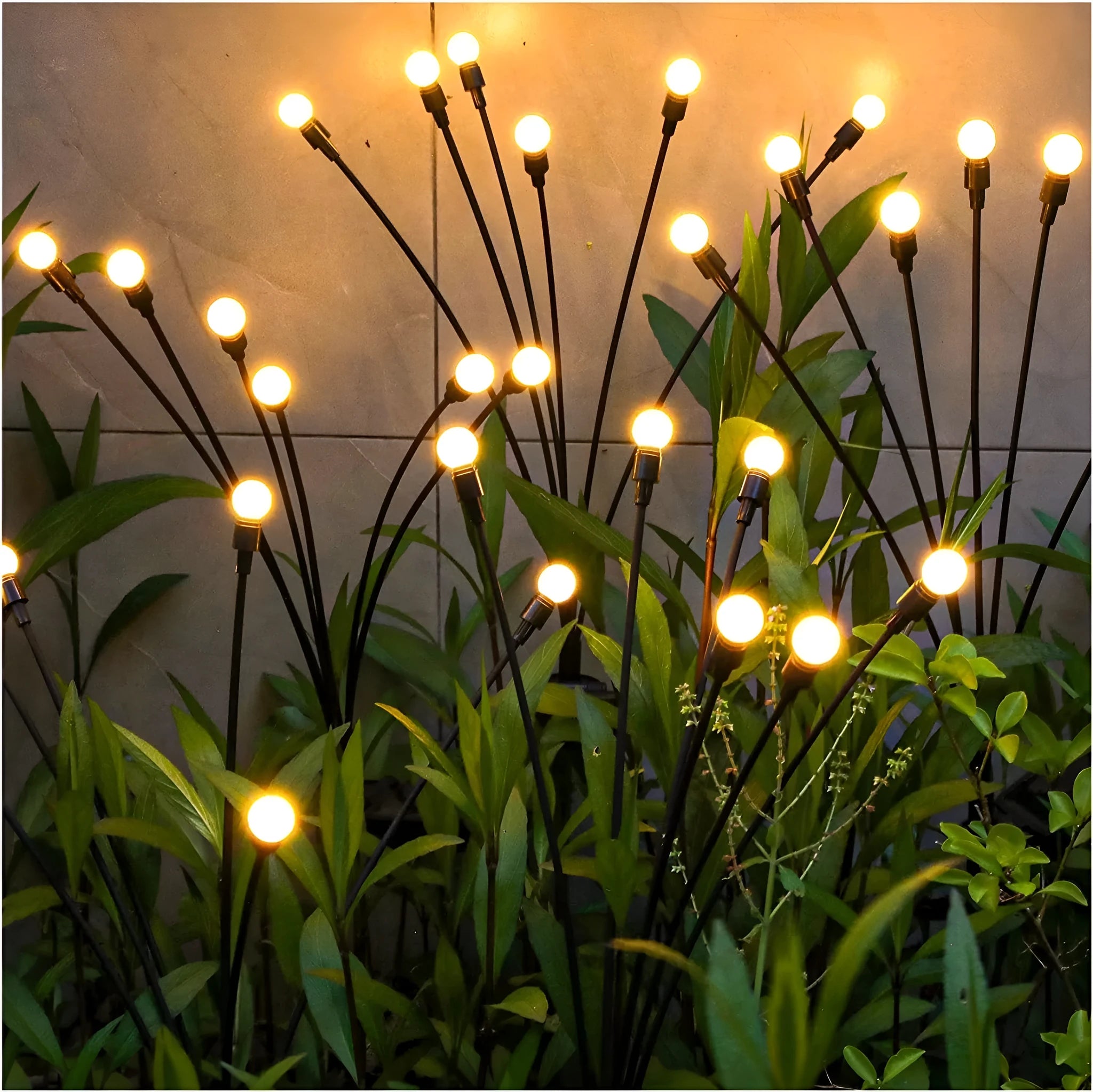 Solar-powered LED firefly garden spike light with stainless steel ground stake illuminated at dusk.