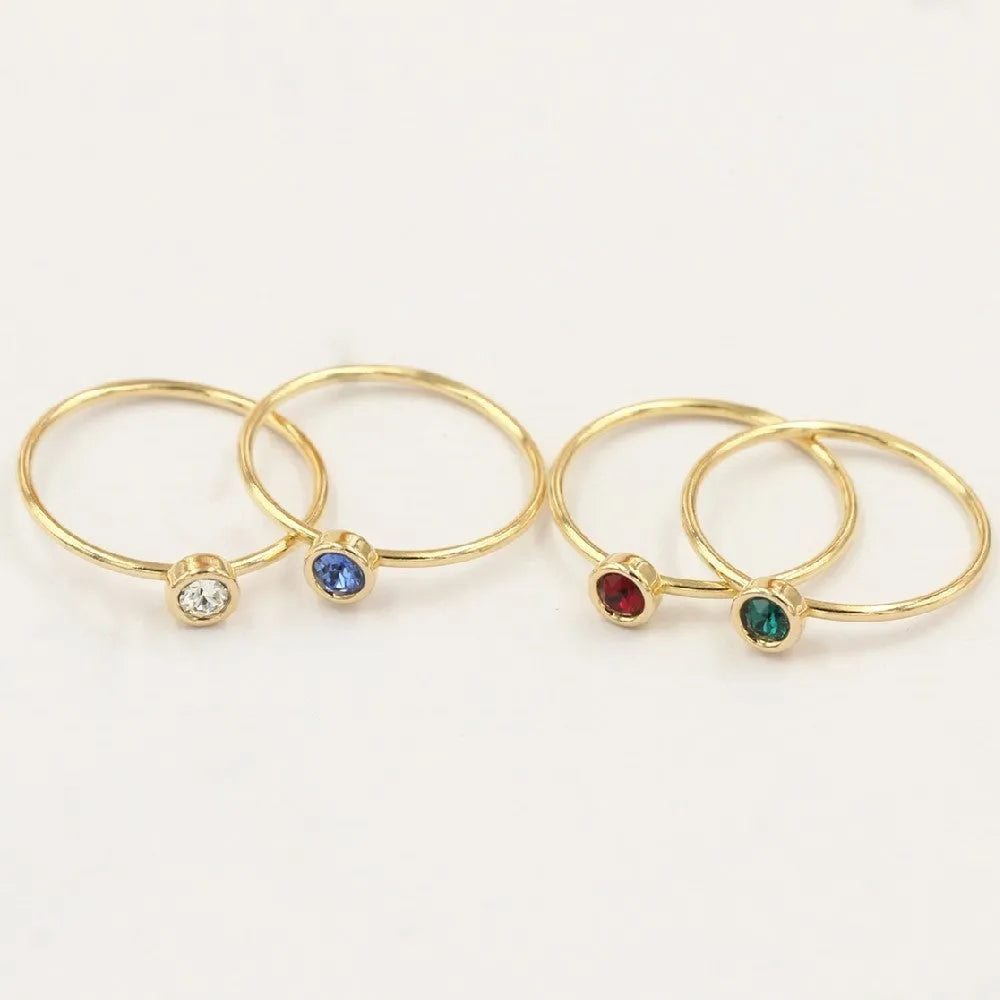 14K gilded gold filled zircon ring on a finger, showing green colour and zircon stones.