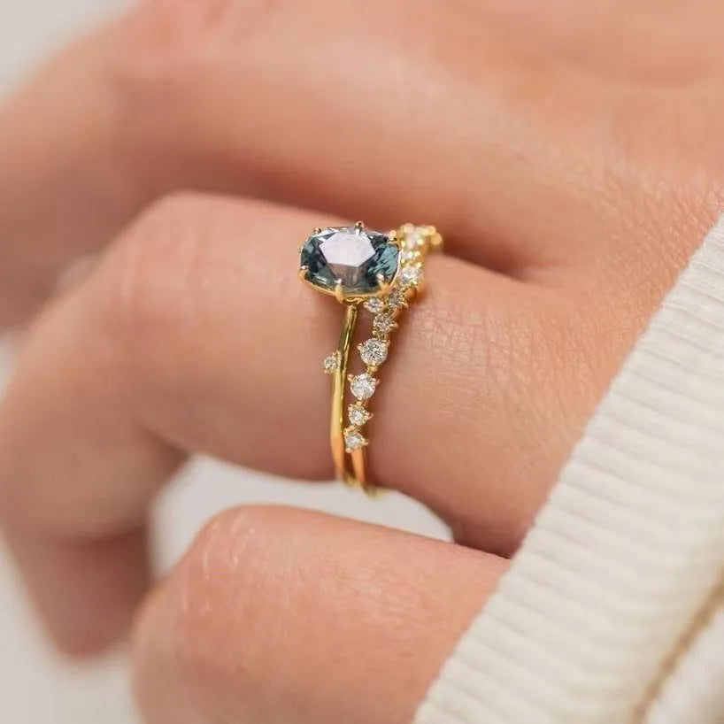 Gold-coloured women's ring with a green zircon stone in a flower-shaped setting.