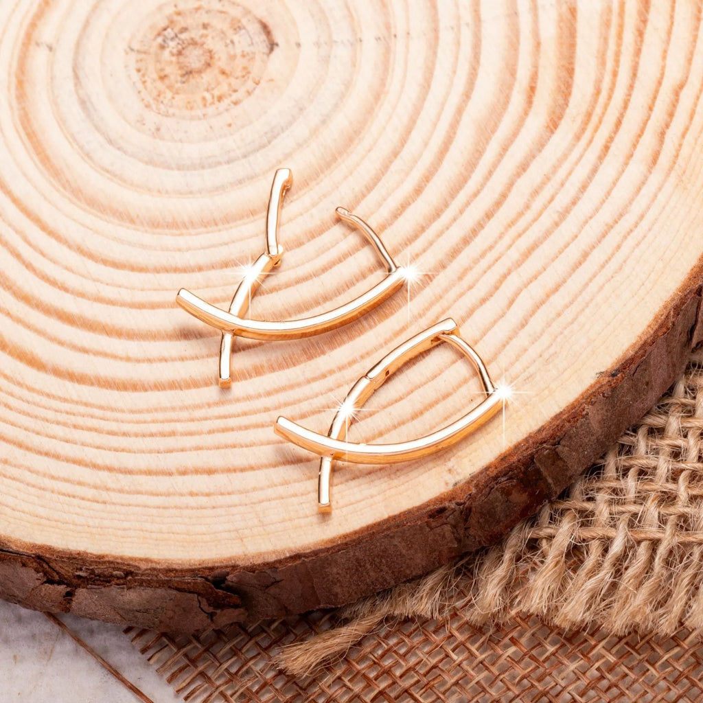 Rose gold cross shaped earrings with metallic finish and pendant design
