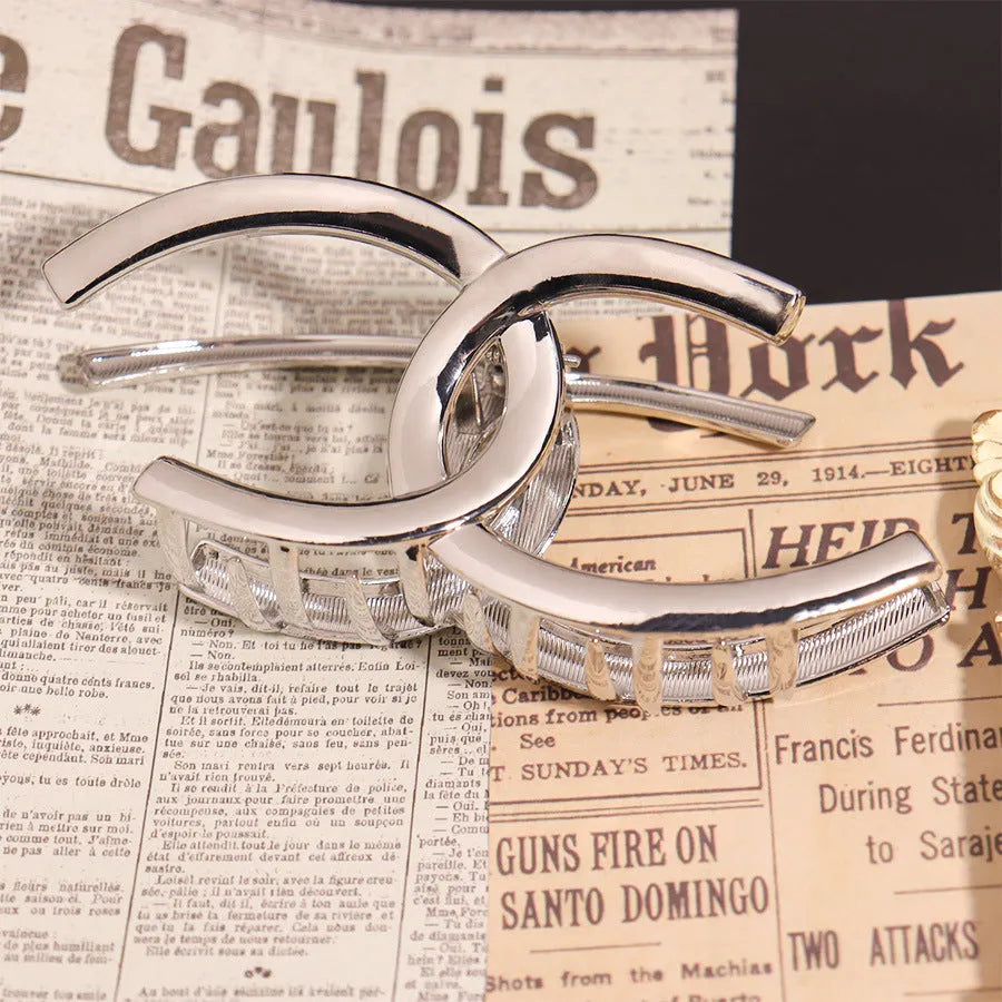 Silver metal hair claw barrettes collection showing multiple designs including wave, rose, and bow shapes
