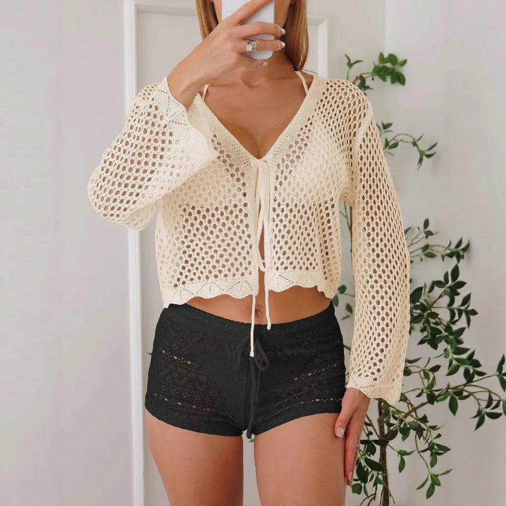 Women's apricot coloured hollow woven blouse with short length and bell sleeves on a hanger.