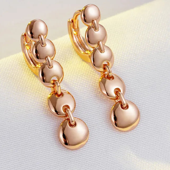 Gold tone retro earrings with a round circle shape and surface weave design, hanging as a dangle.