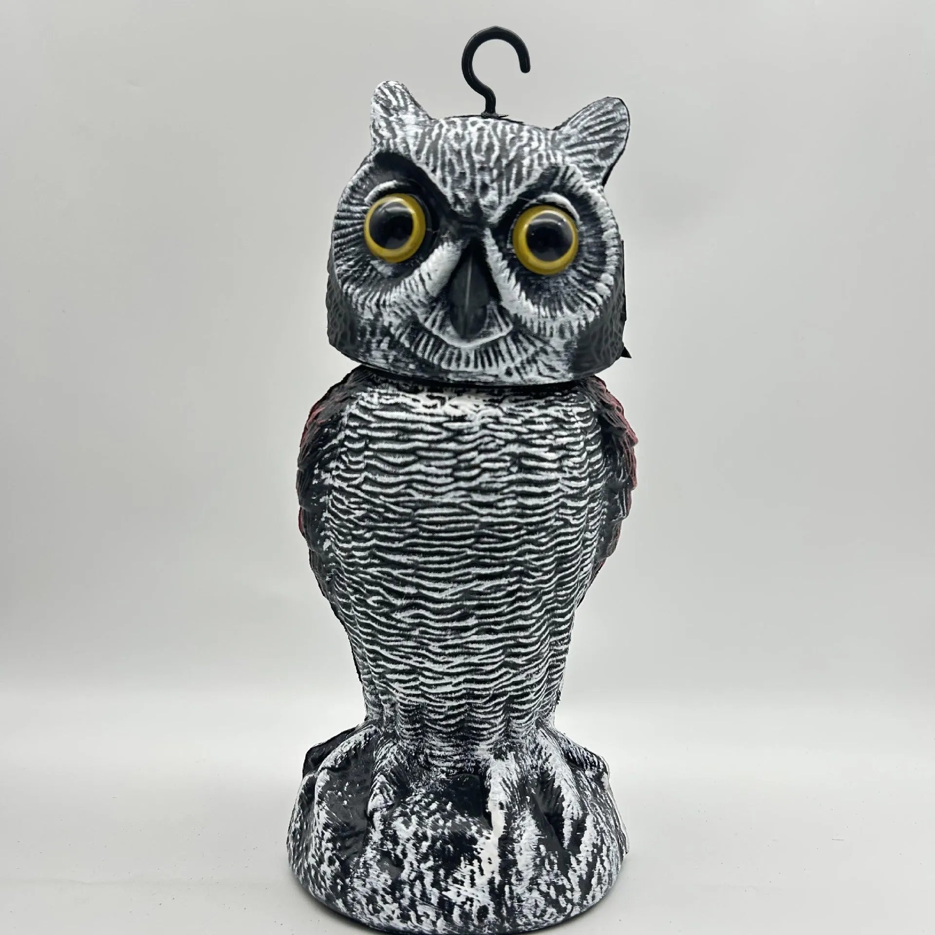 Artificial owl bird deterrent ornament with moving head in outdoor setting