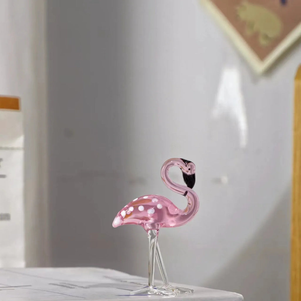 Clear crystal flamingo decorative sculpture with pink dots on a table.