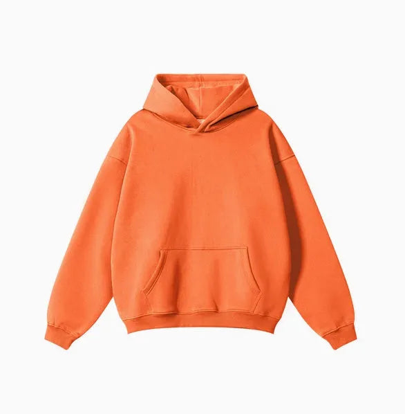 A man wearing a loose-fit, 450g cotton, hooded pullover sweater in a neutral colour with drop-shoulder sleeves.