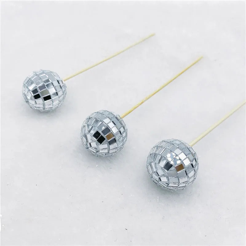 Glass mirror disco ball cake topper on a wooden stick for birthday party cupcakes.