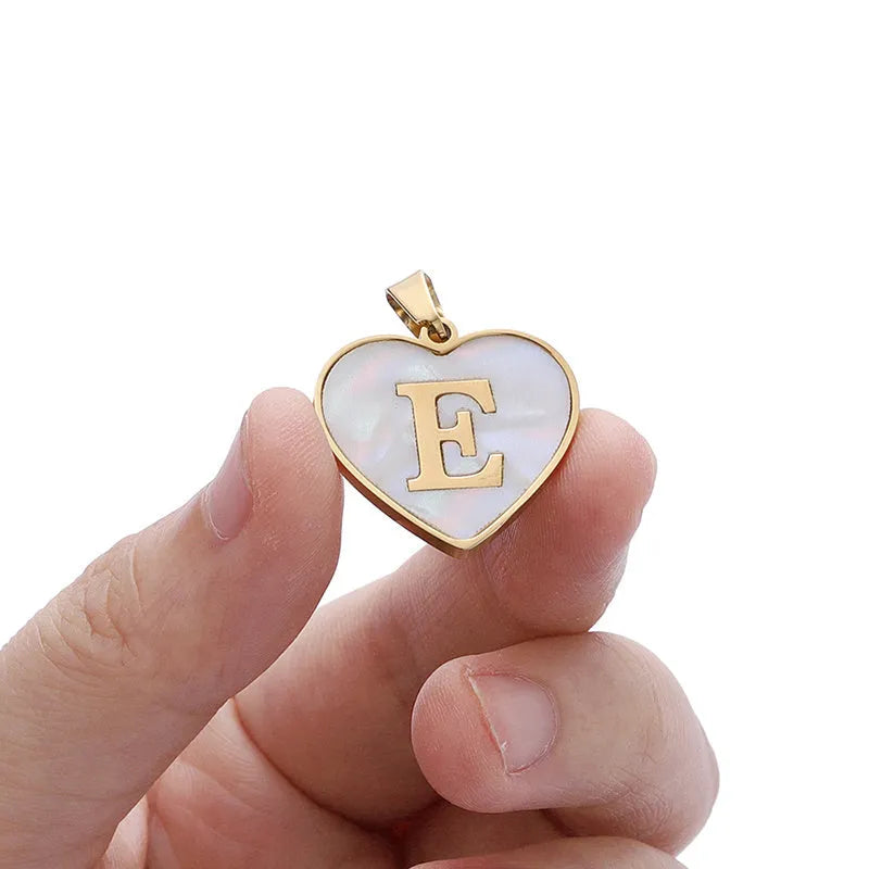 Gold chain necklace with white shell heart pendant featuring single letter customisation option
