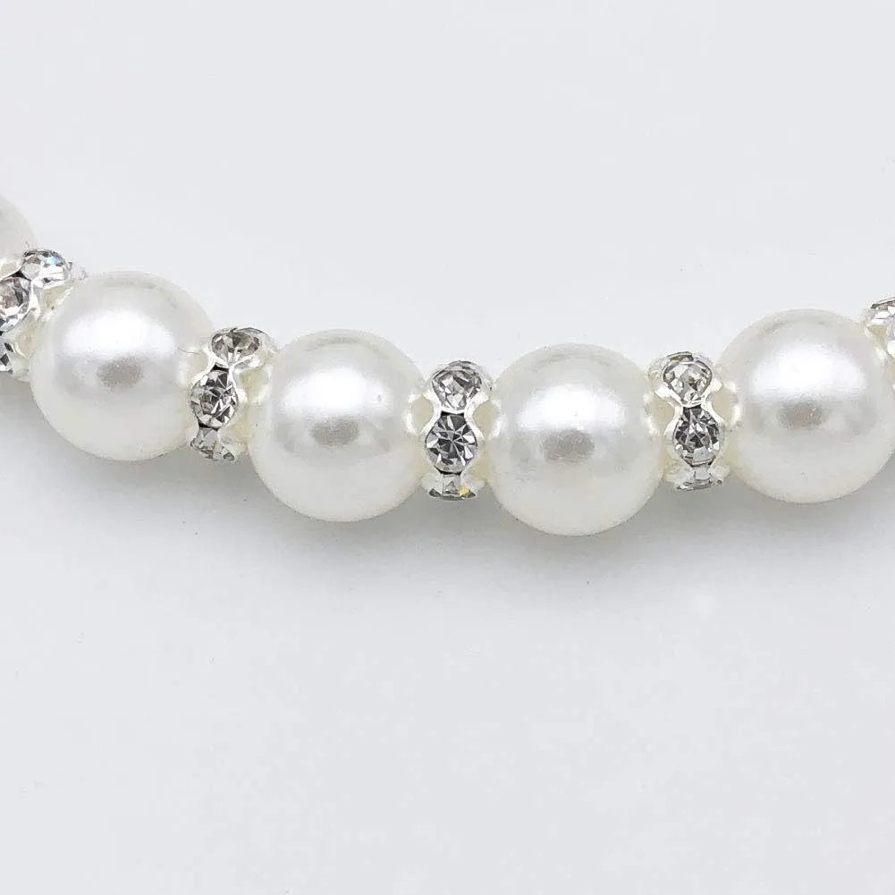 Small dog wearing adjustable pearl necklace with rhinestones and ribbon bow decorative collar