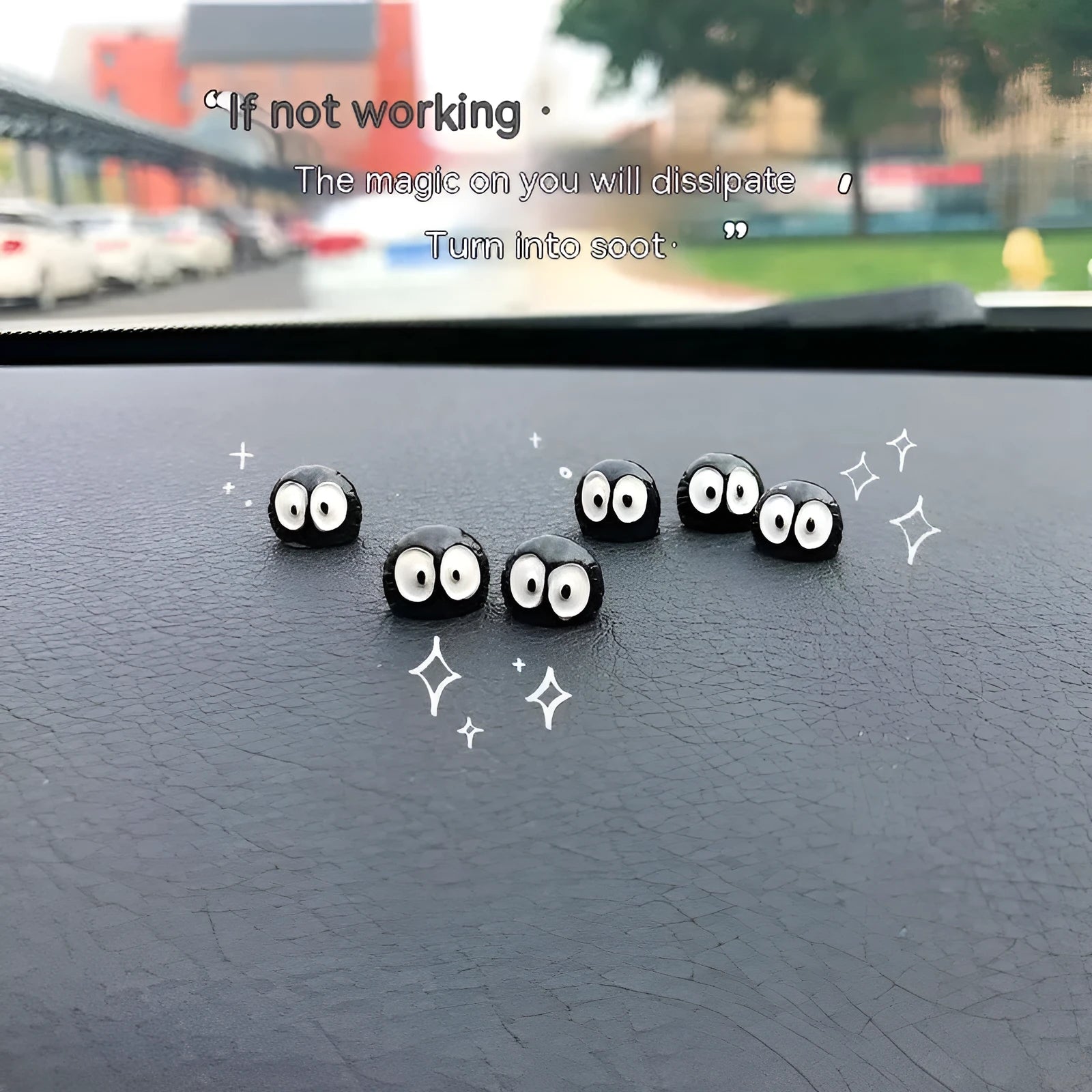 Small black cartoon-styled resin briquette car decoration ornament with traceless glue tape on a surface.