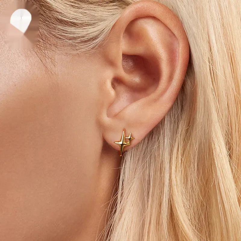 Sterling silver ear clips with minimalist star design and oxidation finish.