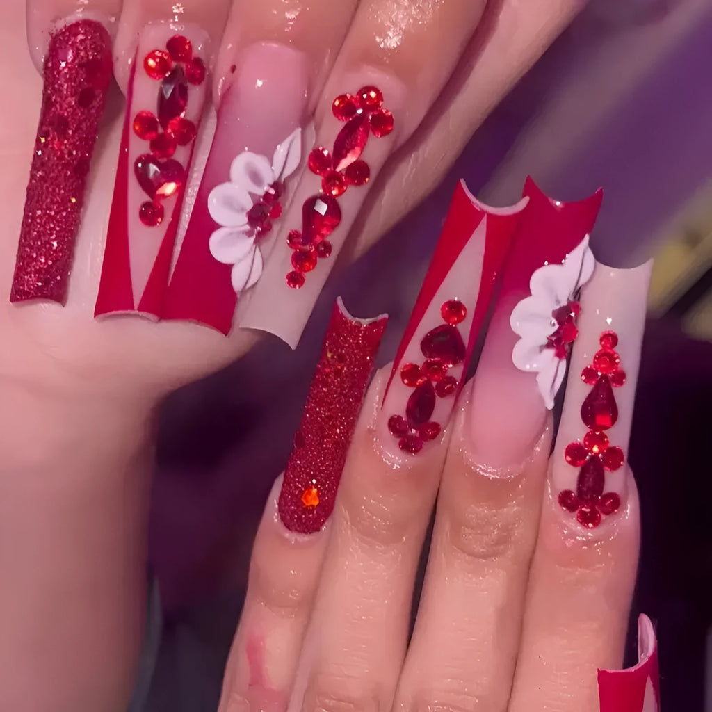 Long European square fake nails with red diamond and flower pattern design, shown with glue and file
