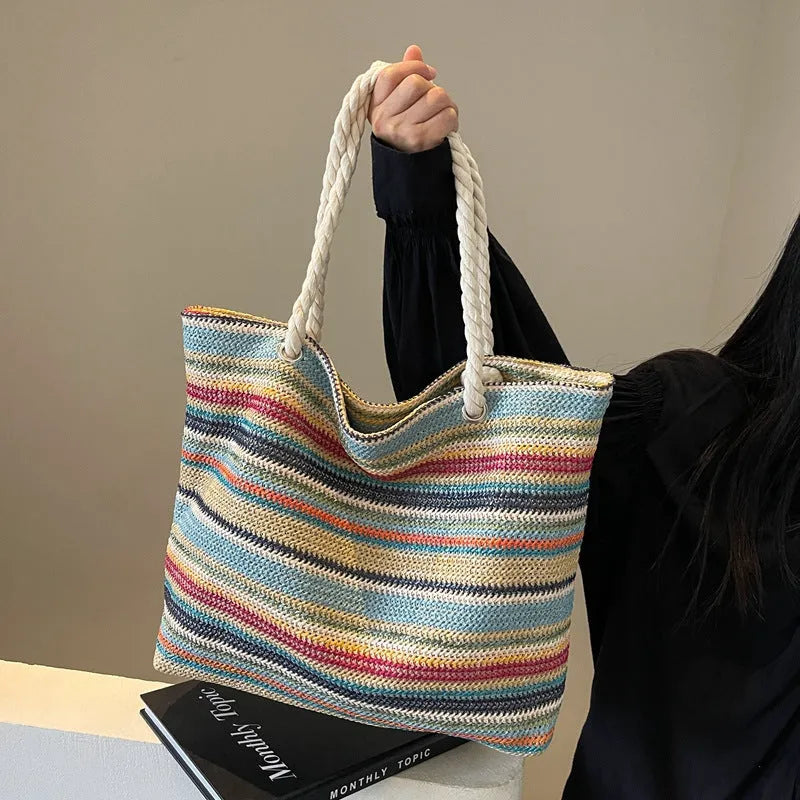 Blue woven straw-effect nylon shoulder bag with a single strap and large main compartment.