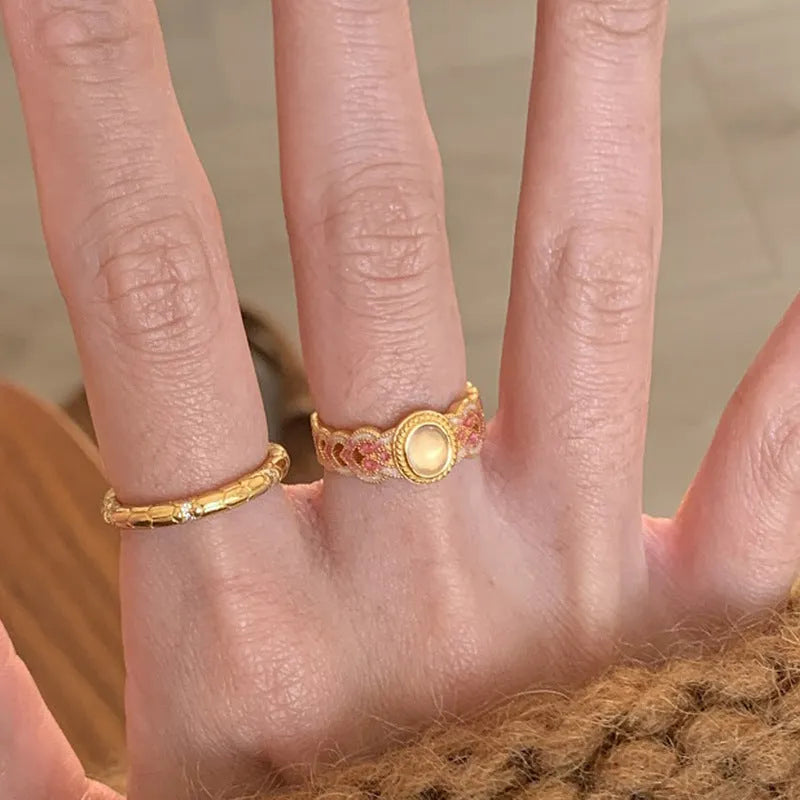 Geometric open mouth ring with pink crystal enamel on a gold-plated copper band.