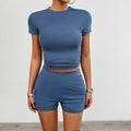 Women's solid colour slim fit sports suit set with short sleeve t-shirt and elastic shorts.