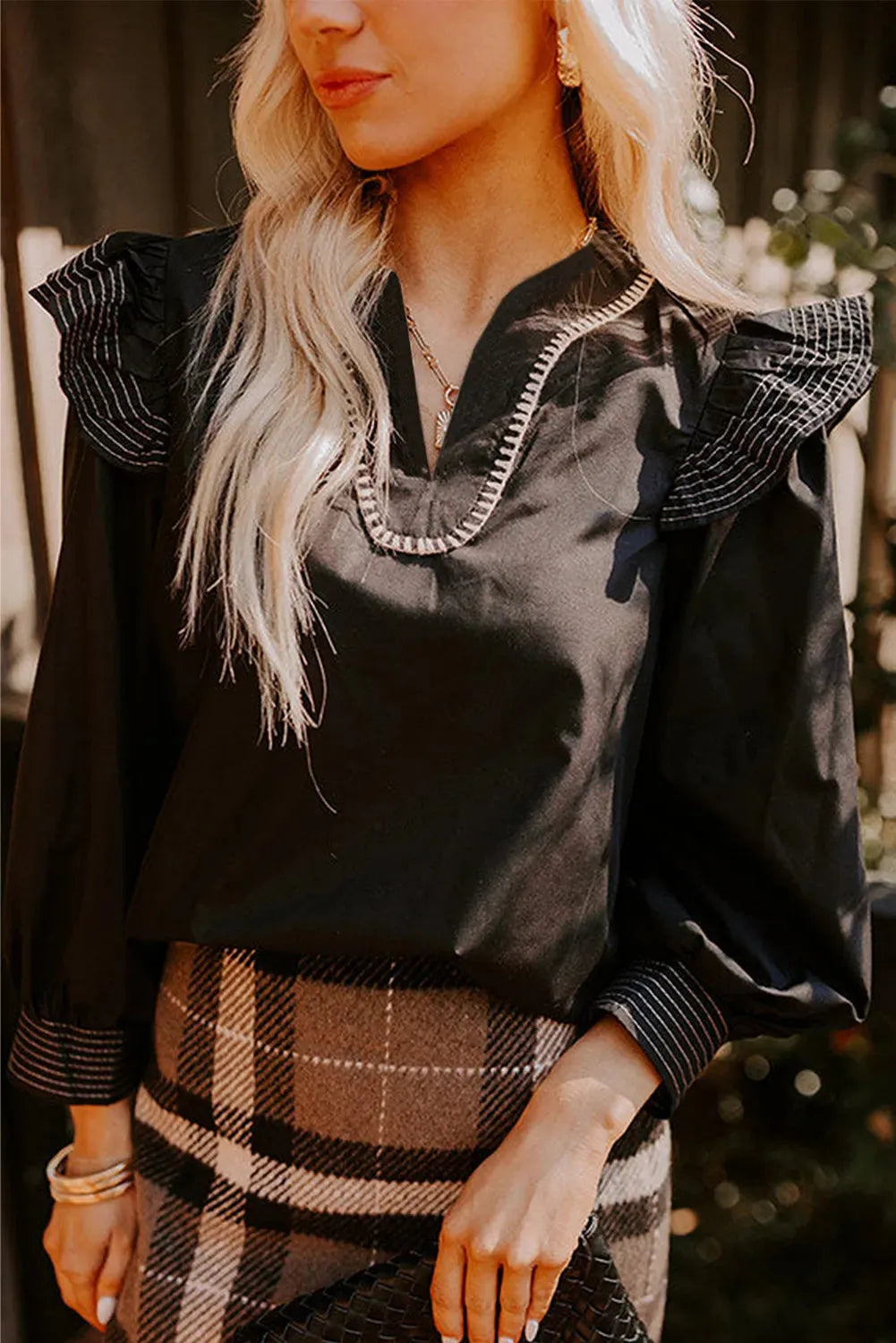 Black women's V-neck long sleeve blouse with ruffle detail and contrast stitching