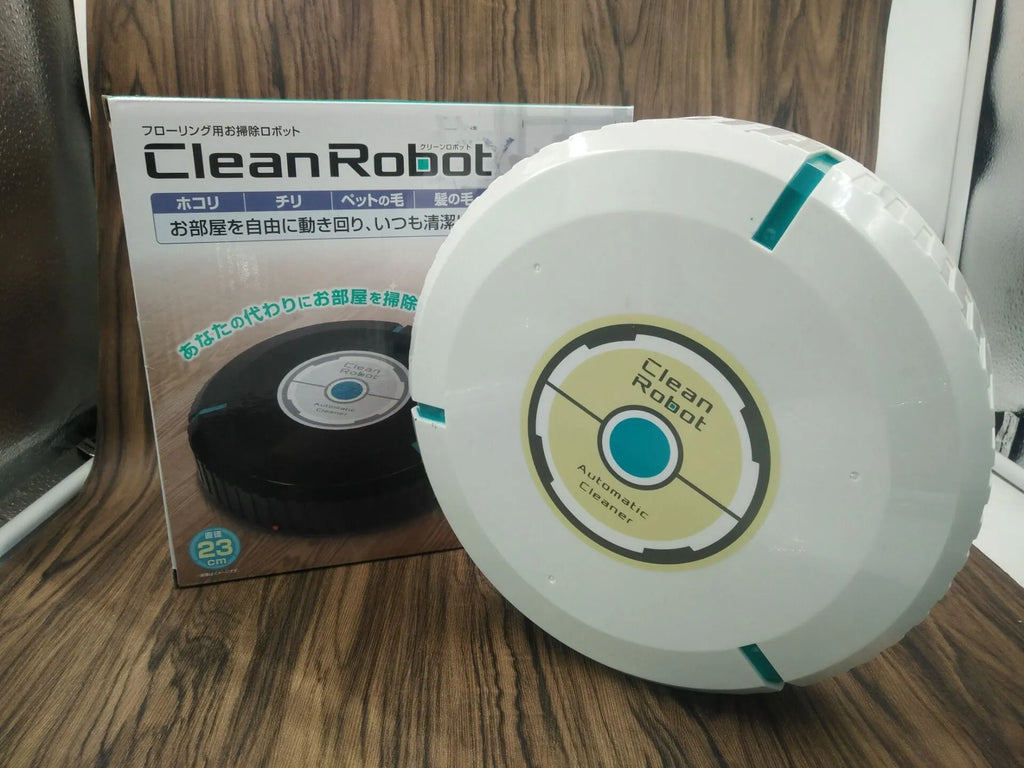Compact black and white robot vacuum cleaner on a wooden floor