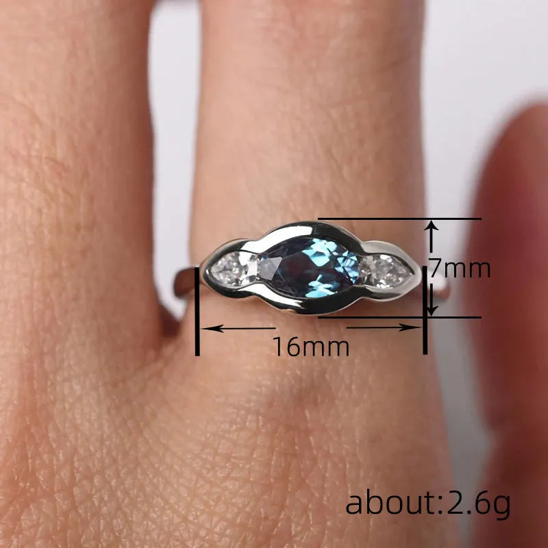 Geometric ellipse-shaped women's ring with inlaid zircon stones in a white gold finish.