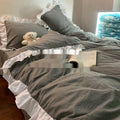 Washed cotton Mori style solid colour bedding four-piece set with quilt cover, sheet, and pillowcases on a bed.