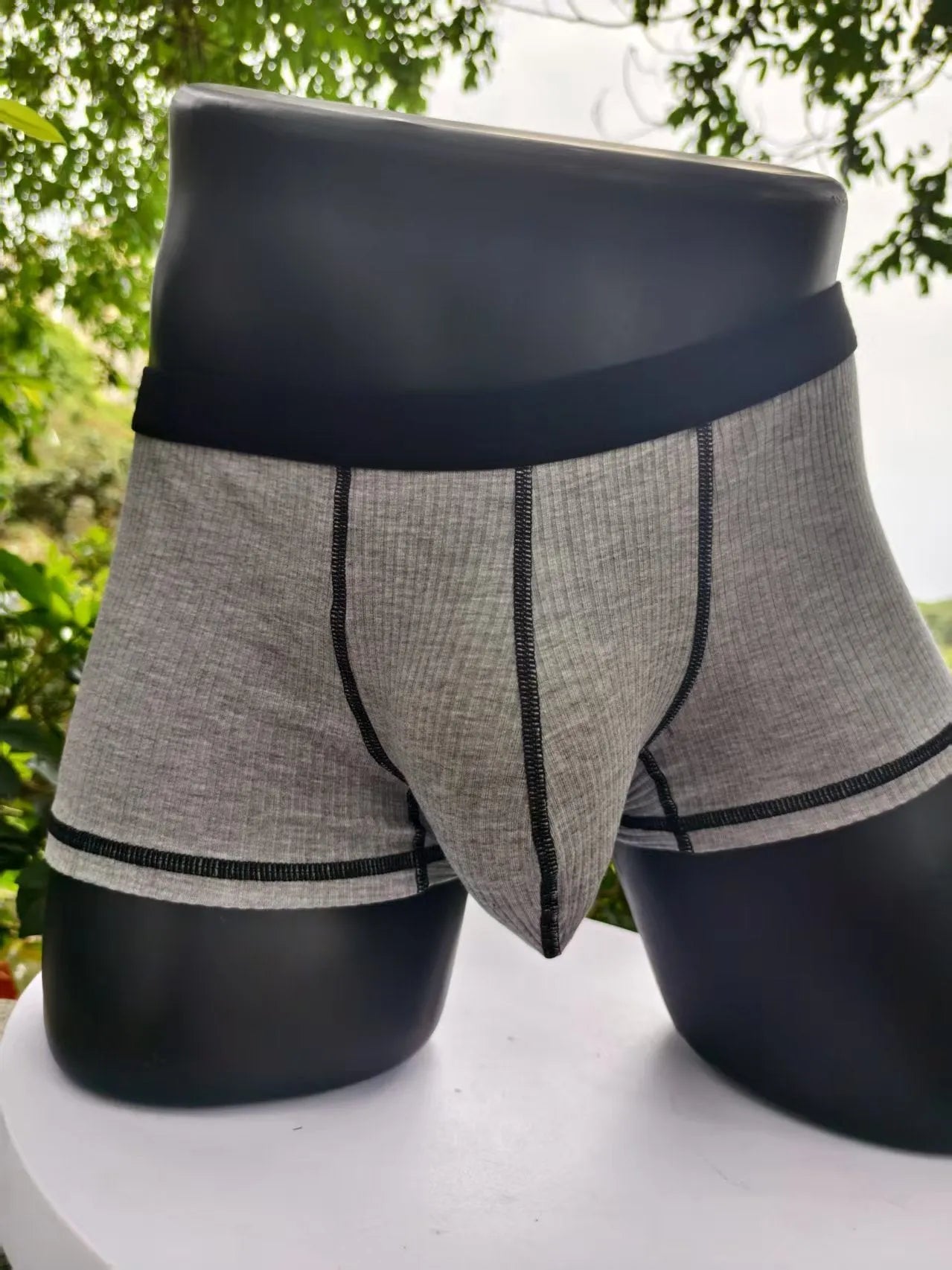 Men's thin fabric boxer shorts in solid colours showing hip lifting design