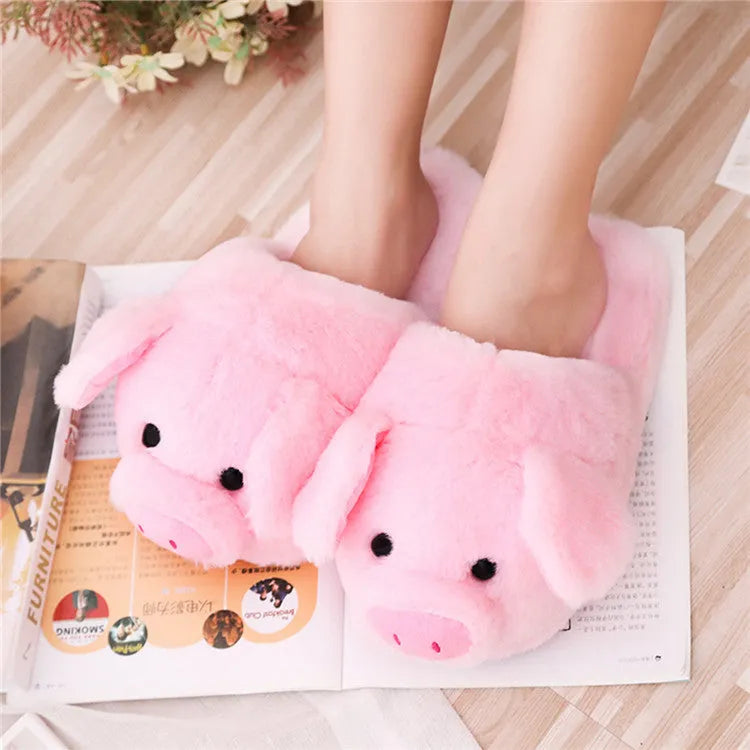 Pink pig-shaped floor slippers with a soft plush fabric exterior.