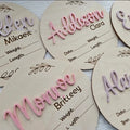 Square wooden baby name label displaying personalised birth details for nursery décor.