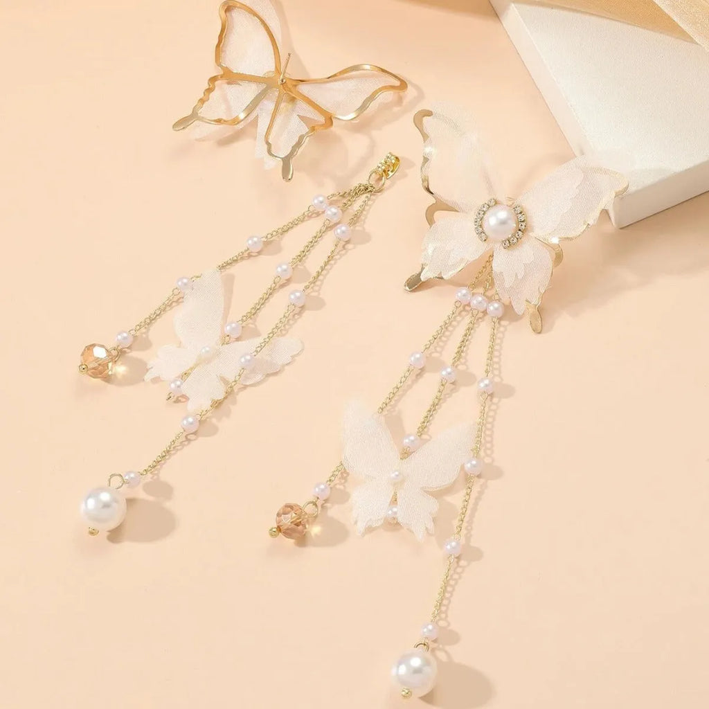 White butterfly-shaped earrings with lace detail, pearls, rhinestones, and a dangling tassel.