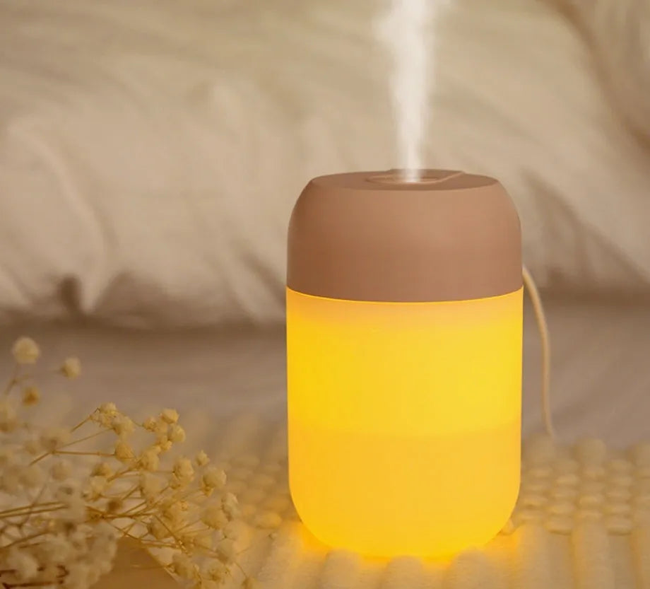 White cylindrical mini USB humidifier with aromatherapy function on wooden desk