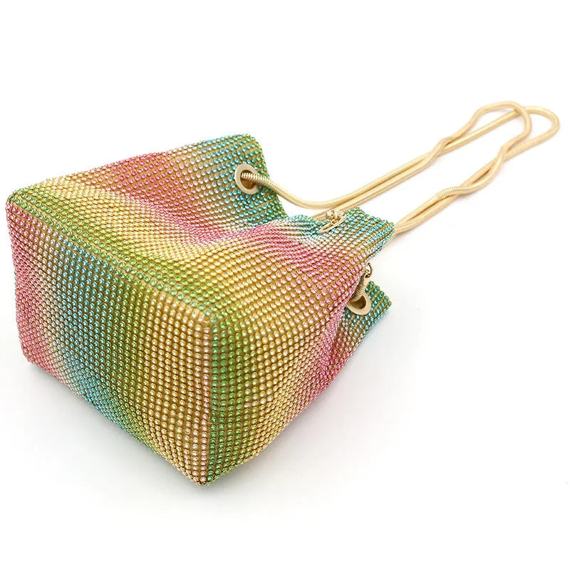 Rainbow rhinestone bucket bag with glittering crystals and a metal chain strap.