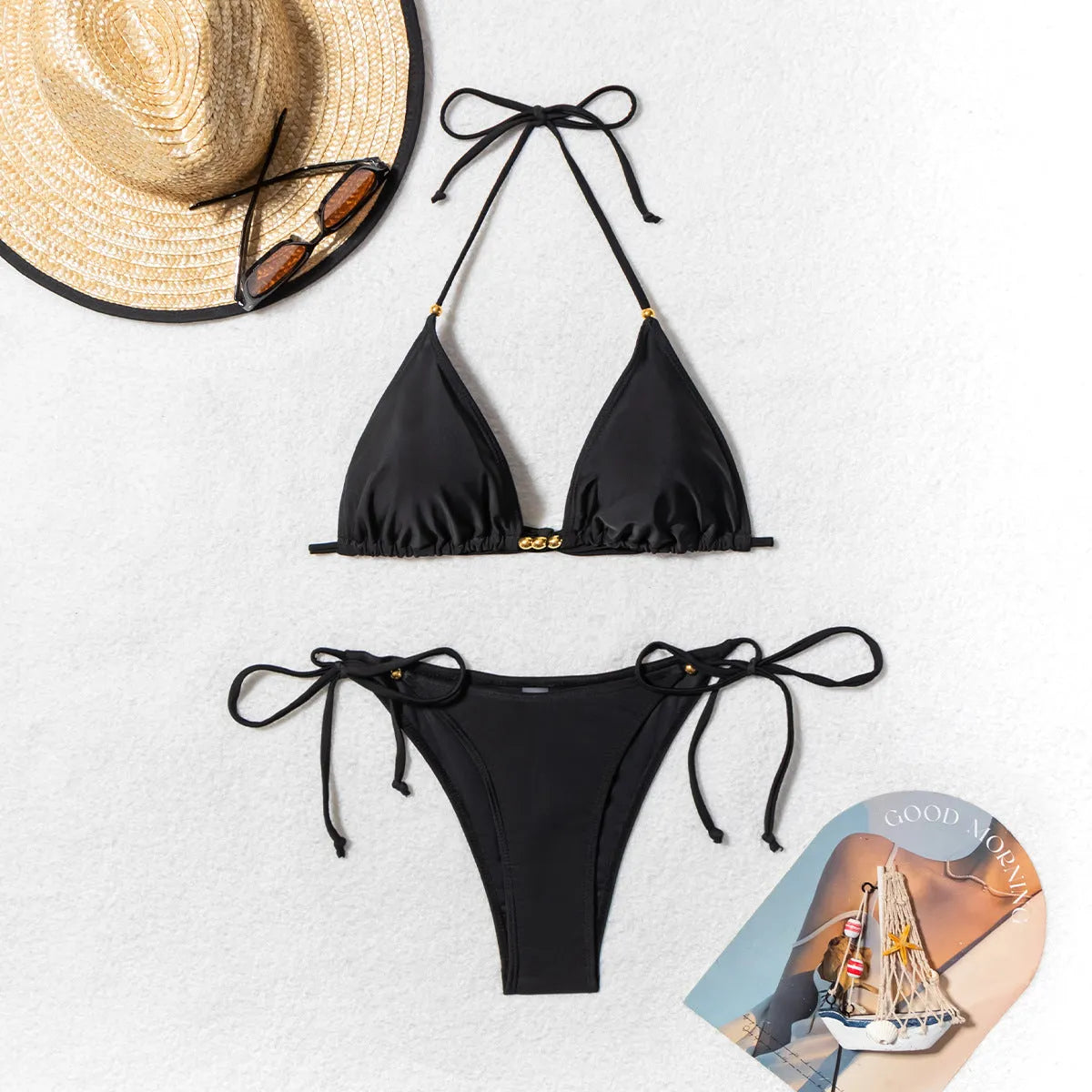 Black women's bikini swimsuit with metal bead decoration and split-side design.