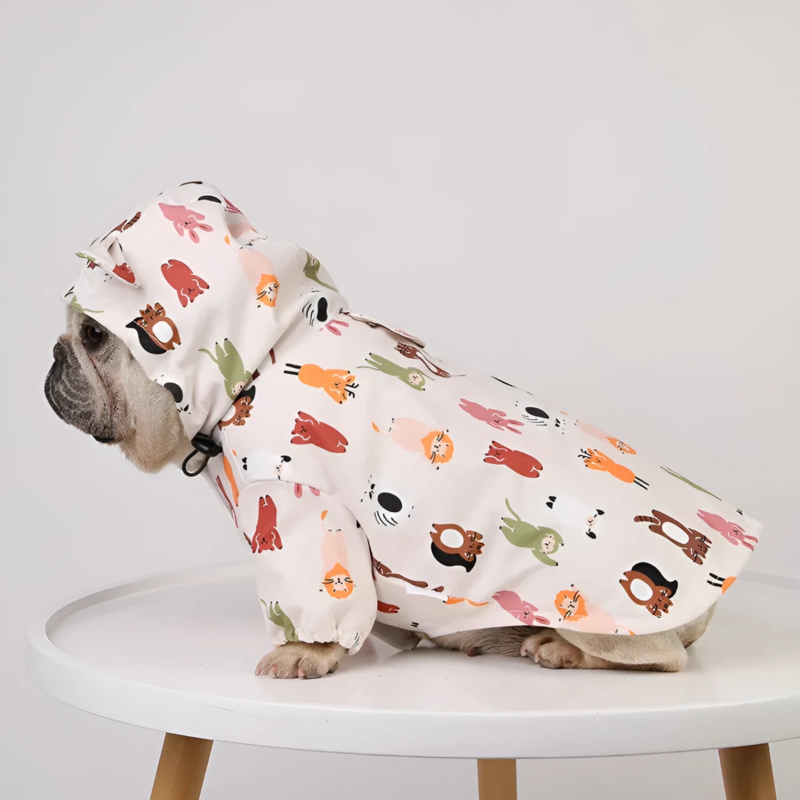 Beige dog raincoat with cartoon cat head pattern, showing waterproof PU material