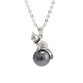 Close-up of a sterling silver cat pendant on a clavicle necklace chain.