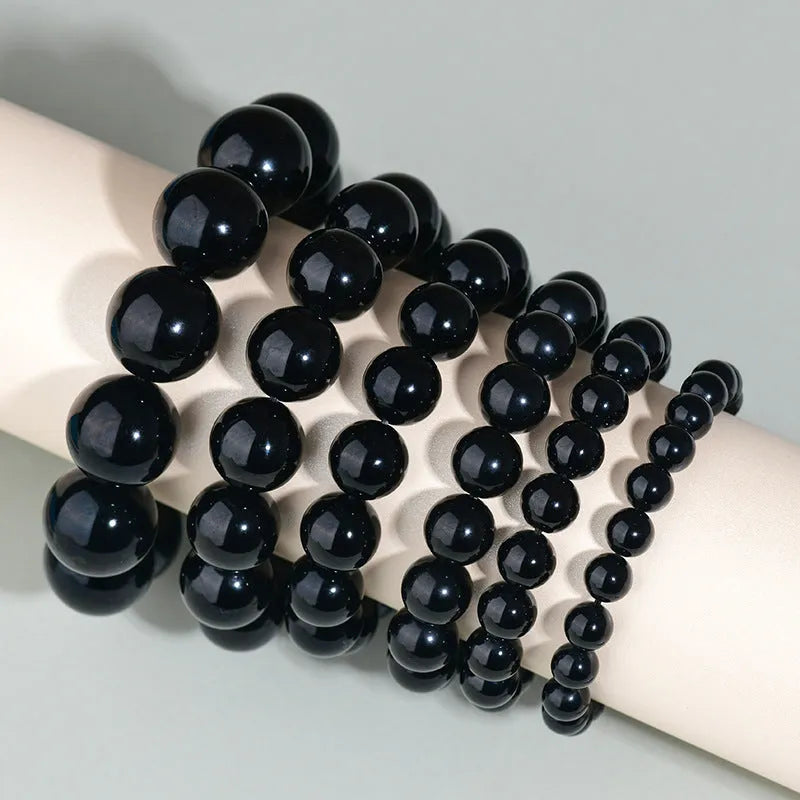 Hand-woven obsidian bracelet with round crystal beads in natural black stone