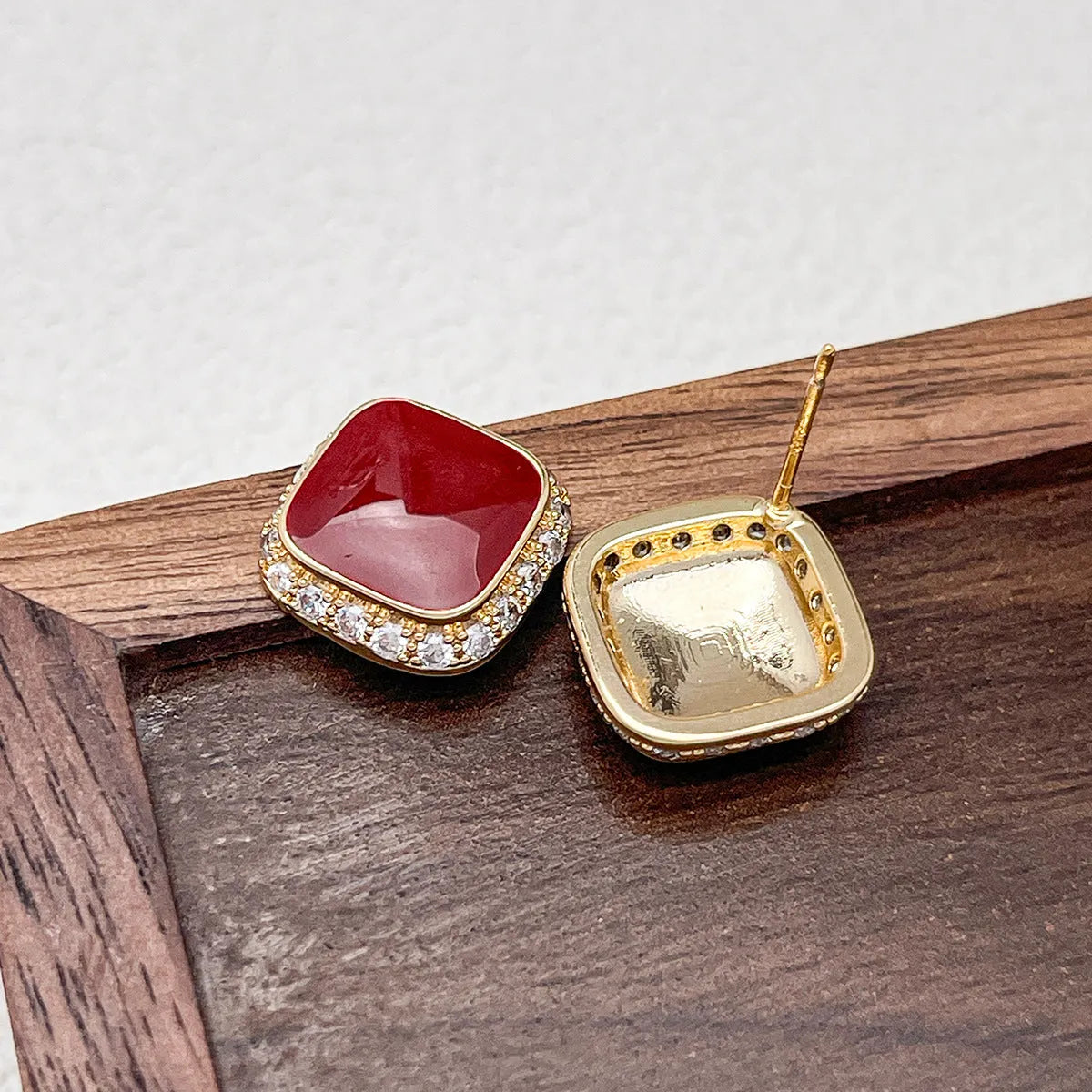 Red geometric square earrings with inlaid design details on alloy material