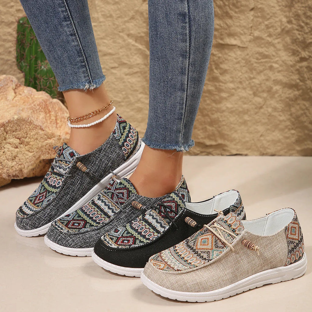 Women's flat slip-on shoes in black with round toe and rubber sole on a white background