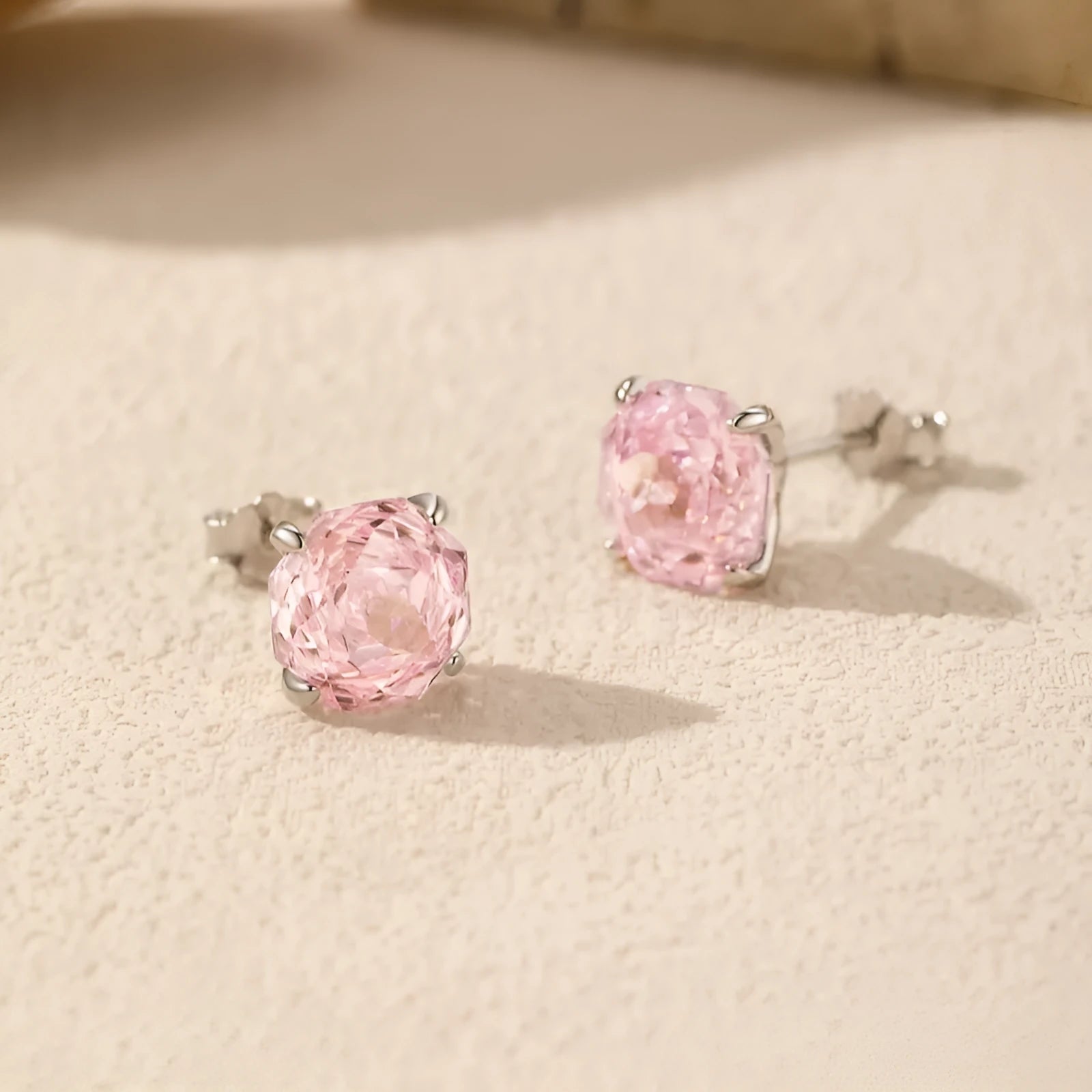 Close-up of pink rose-shaped stud earrings made from S925 sterling silver, shown on a plain background.