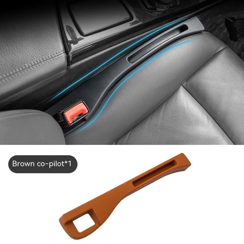 Black plastic car seat gap storage box with removal handle inserted between vehicle seats