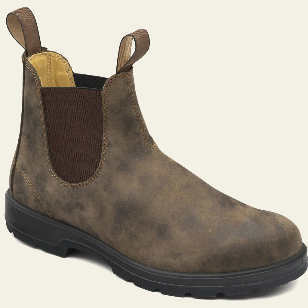 Vintage brown frosted finish Chelsea boots with car suture detailing on a wooden floor.