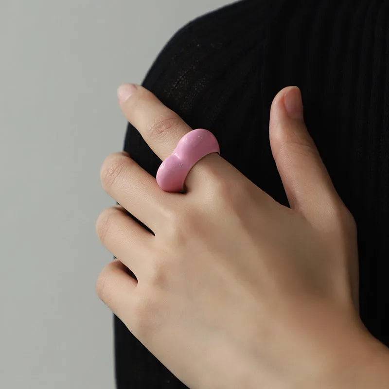 A three-dimensional heart-shaped enamel ring in zinc alloy, shown in various colours.
