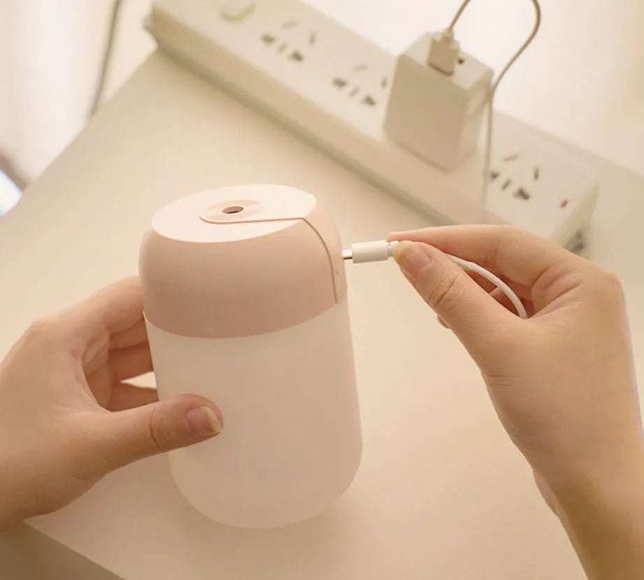 White cylindrical mini USB humidifier with aromatherapy function on wooden desk