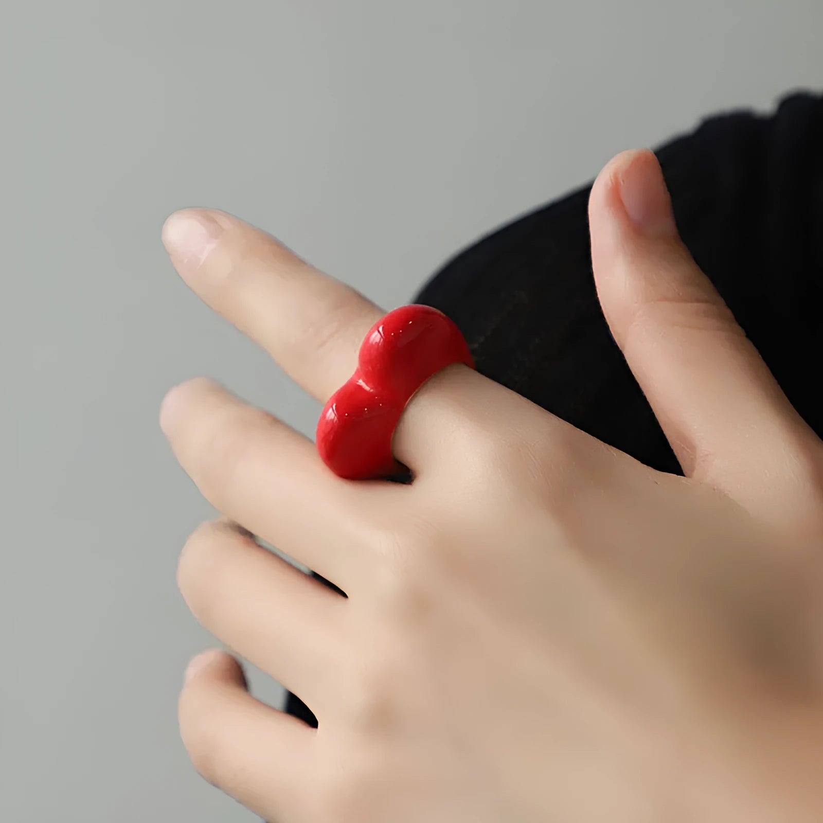 A three-dimensional heart-shaped enamel ring in zinc alloy, shown in various colours.