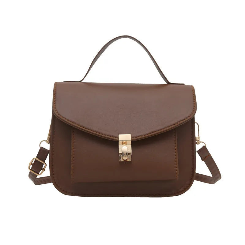 Horizontal square black PU messenger bag with a front sandwich pocket and visible sewing lines.