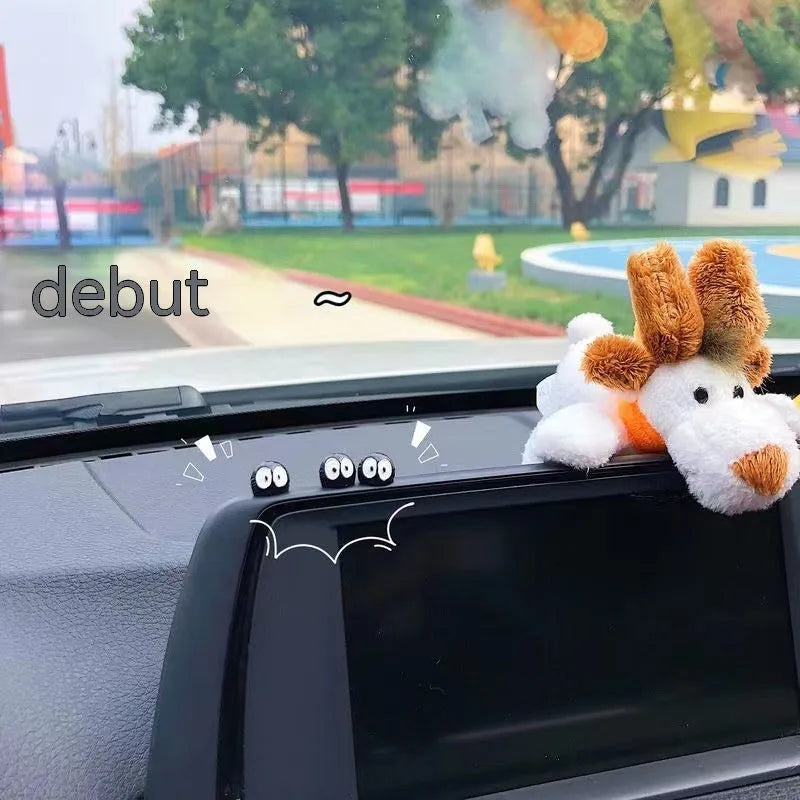 Small black cartoon-styled resin briquette car decoration ornament with traceless glue tape on a surface.