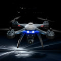 White plastic quadrocopter drone with four rotors, a dual camera system on the front, and blue propeller guards.