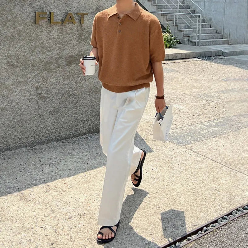 Man wearing a caramel-coloured loose-fit knitted polo shirt with short sleeves and an asymmetrical design detail.