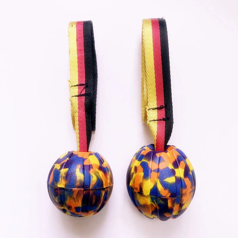 Floating EVA tetherball dog toy in yellow with attached retrieval string on water surface
