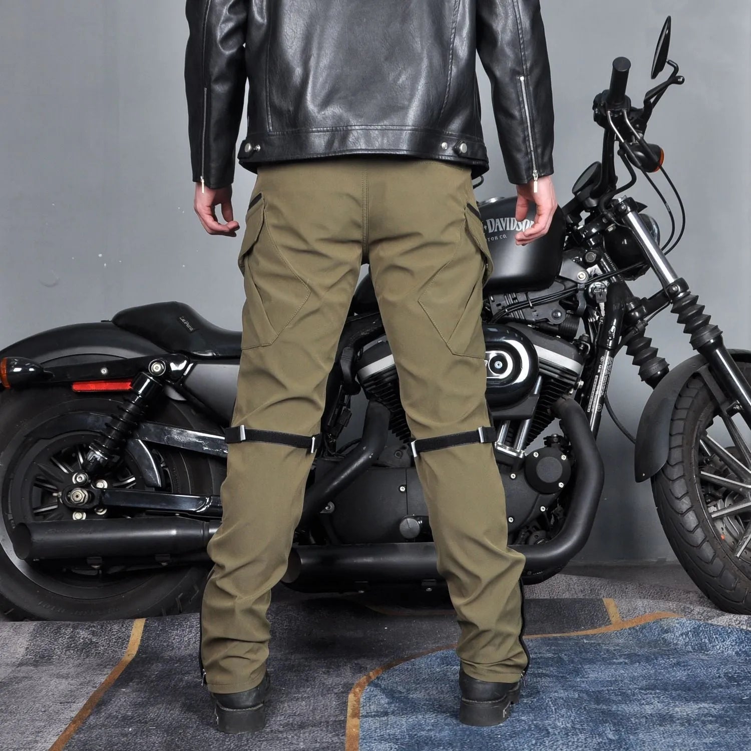 Men's black waterproof motorcycle pants with belt and protective gear set on a neutral background.